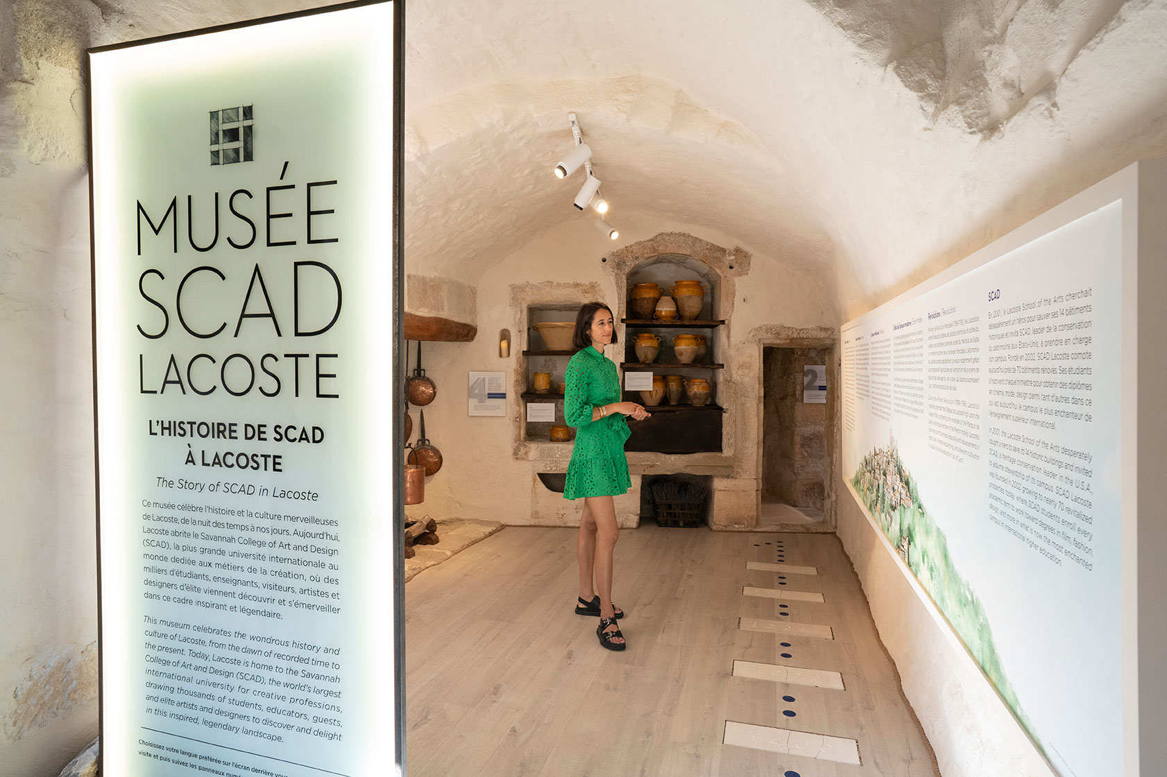 Woman in green dress standing in Musée SCAD Lacoste.